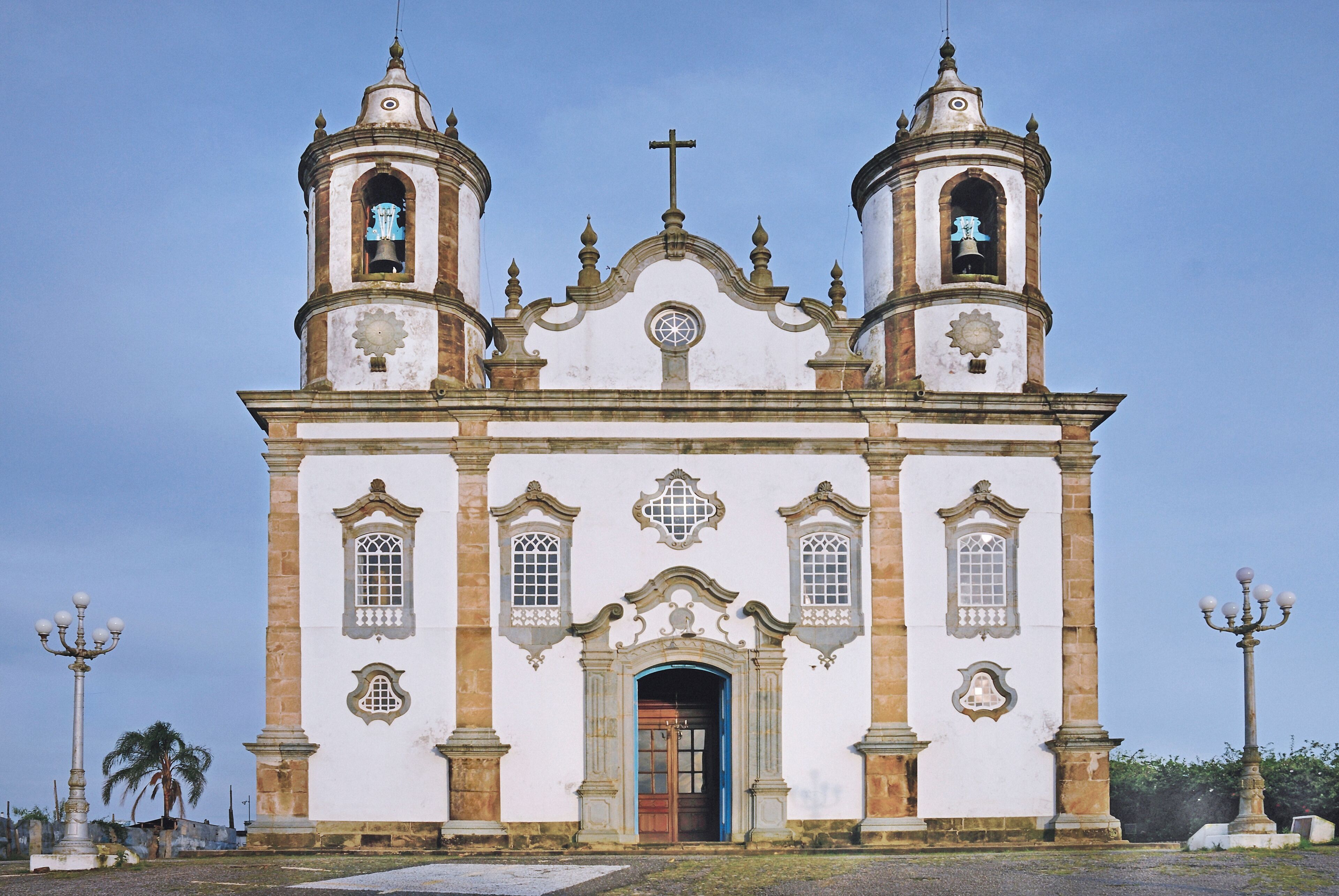 A historic church with two bell towers, a central dome, and a cross at the top.