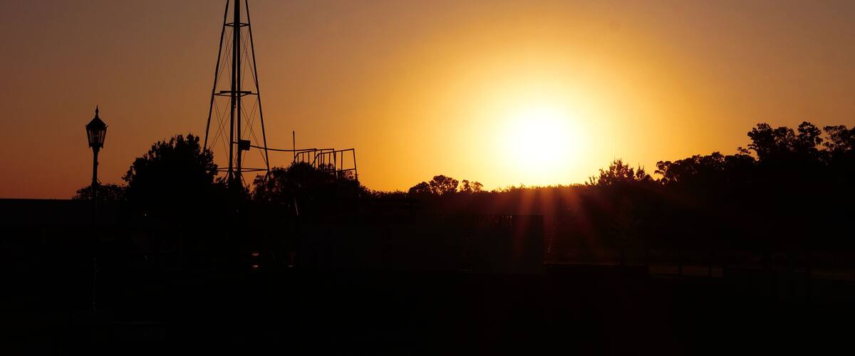 A windmill silhouetted against a sunset.