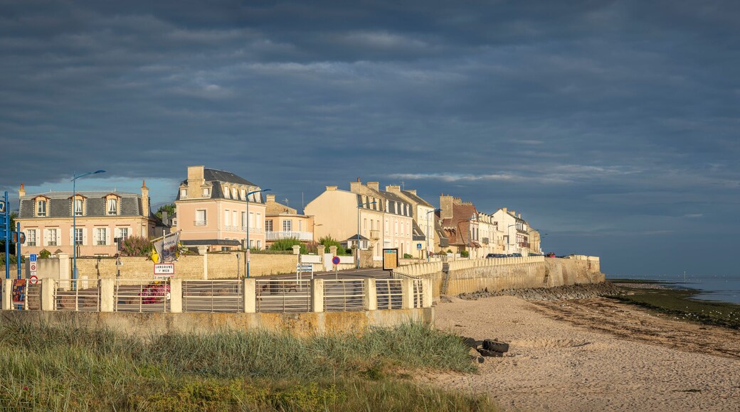 Langrune-Sur-Mer, France - 08 07 2025: Panoramic view of the jetty, the beach and the sea with a sunny cloudy sky