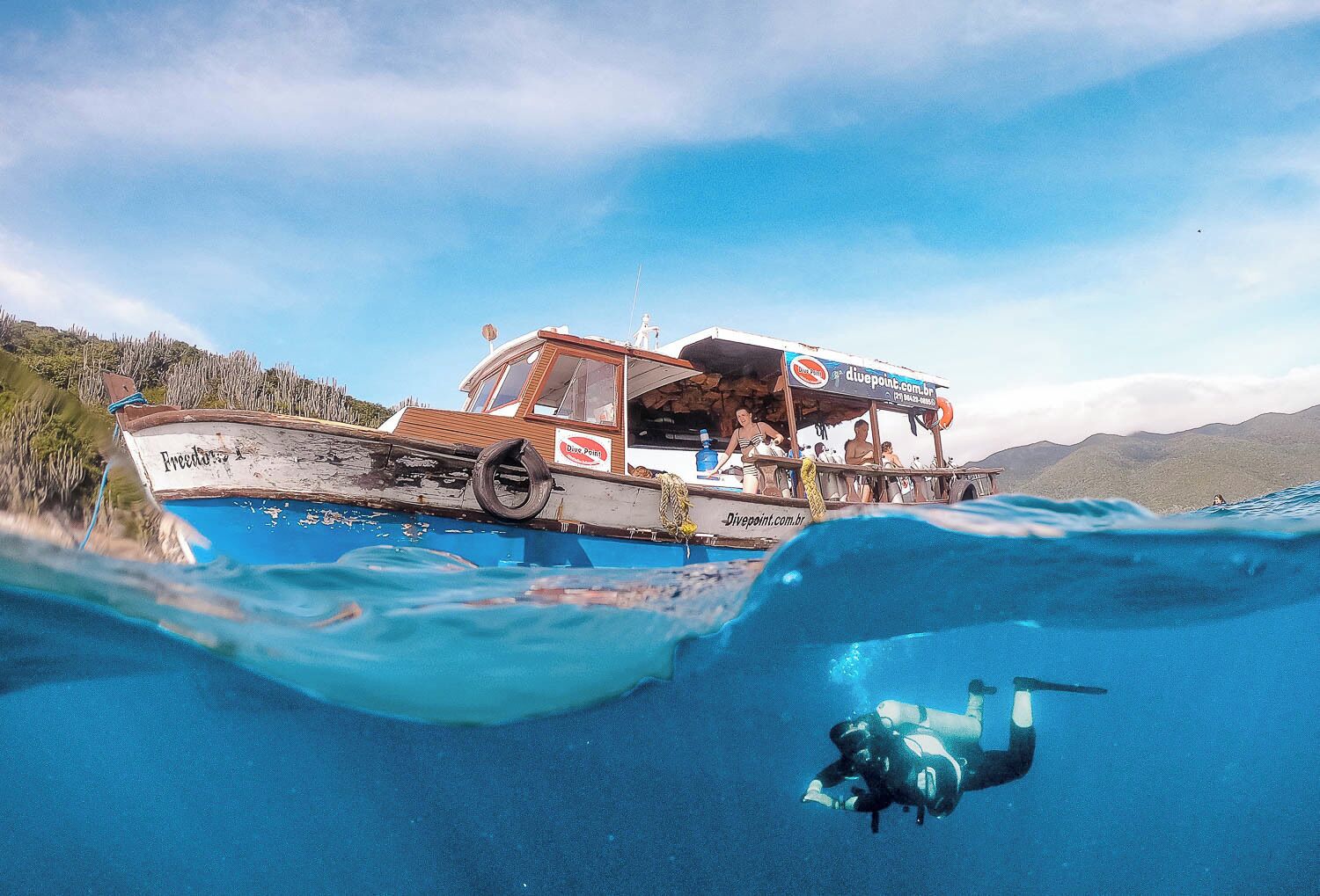 A boat named 'Fresco' with 'Divepoint' branding, partially submerged in clear blue water.