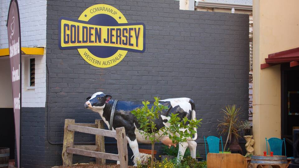 A mural of a cow and a fence in front of a building with a sign that reads "Golden Jersey".