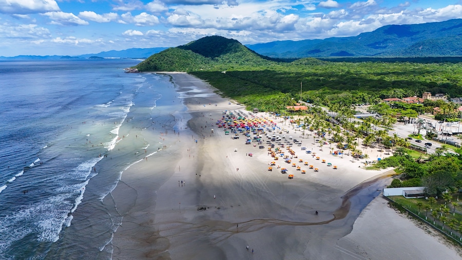 Vista aérea da Praia de Boraceia em Bertioga, litoral de São Paulo, mostrando mar aberto, extensa faixa de areia, vegetação costeira e área residencial próxima à orla