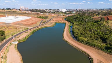 Un río serpentea por un paisaje, con una carretera a un lado y una extensa zona industrial al otro.