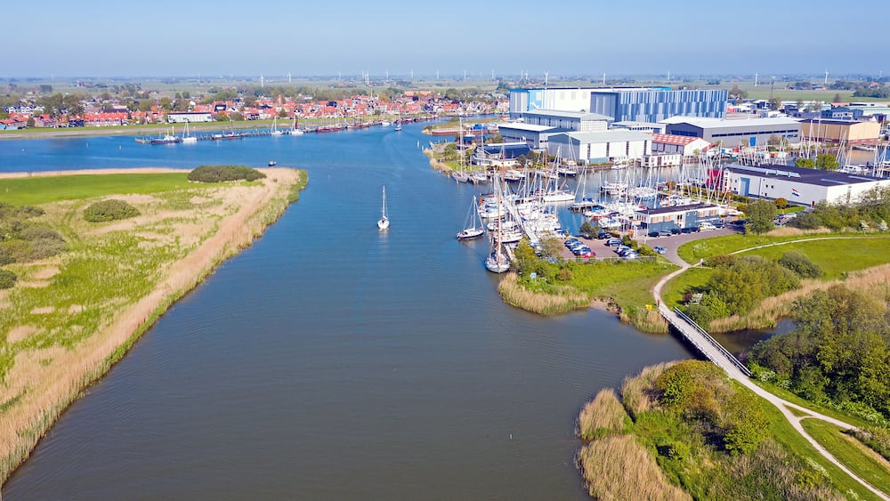 Ein Fluss mit Booten, einem Hafen und einem großen Industriegebäude.