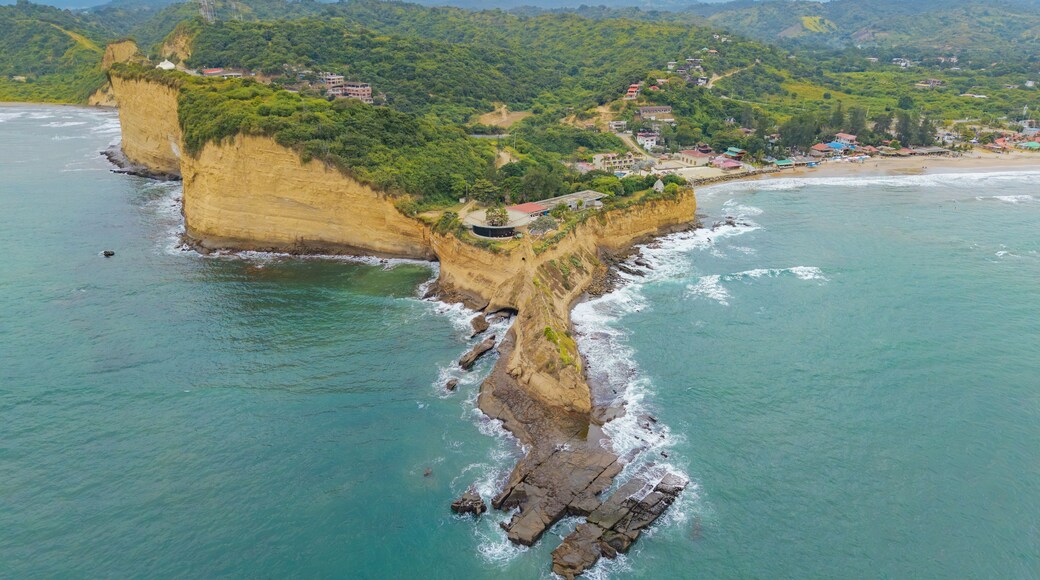 Aerial view of the dramatic coastal cliffs and lush green headland of Montanita jutting into the turquoise Pacific Ocean in Montanita, Santa Elena, Ecuador.