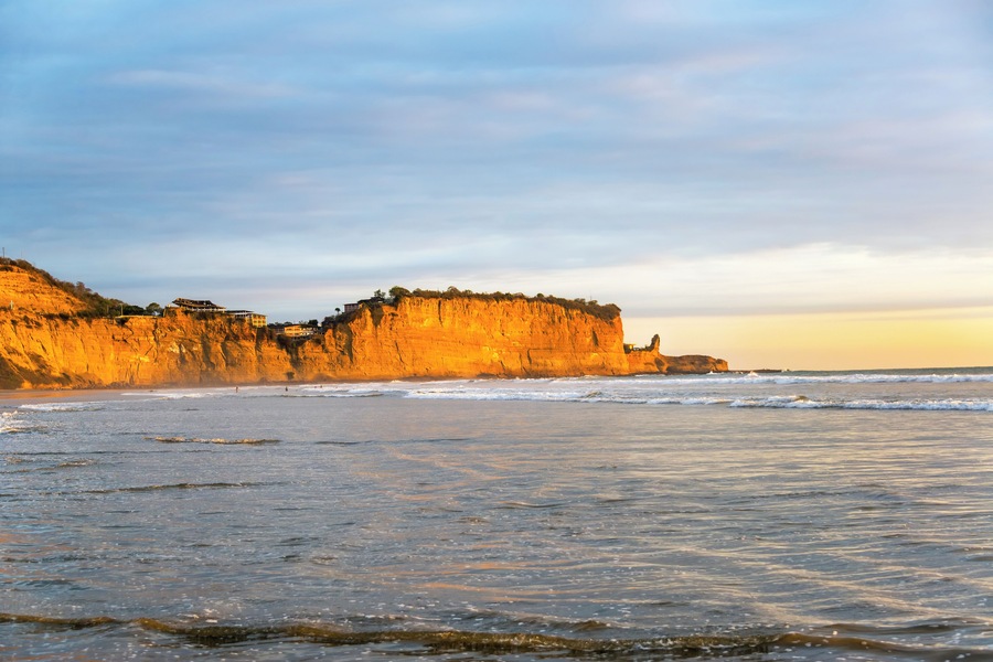 Golden light falling on the cliffs near the beach town of Montanita, Ecuador