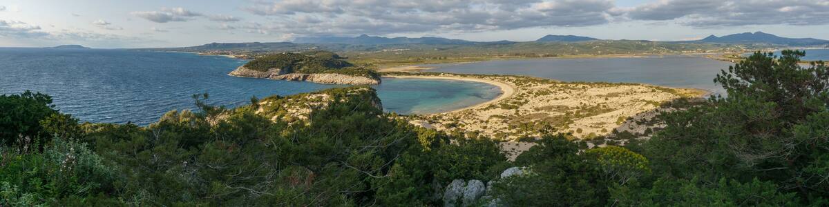 Panorama of idyllic voidokilia beach with turquoise colored water from a high point of view on a sunny spring day, Messinia, Peloponnese, Greece