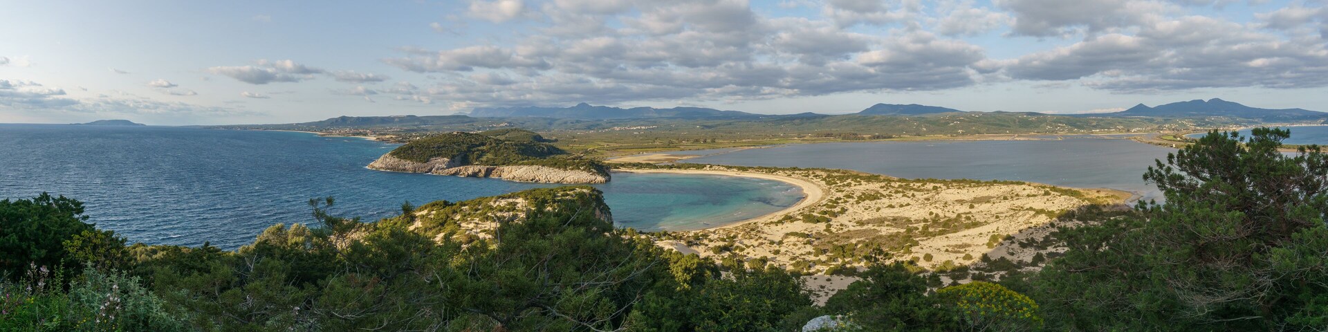Panorama of idyllic voidokilia beach with turquoise colored water from a high point of view on a sunny spring day, Messinia, Peloponnese, Greece