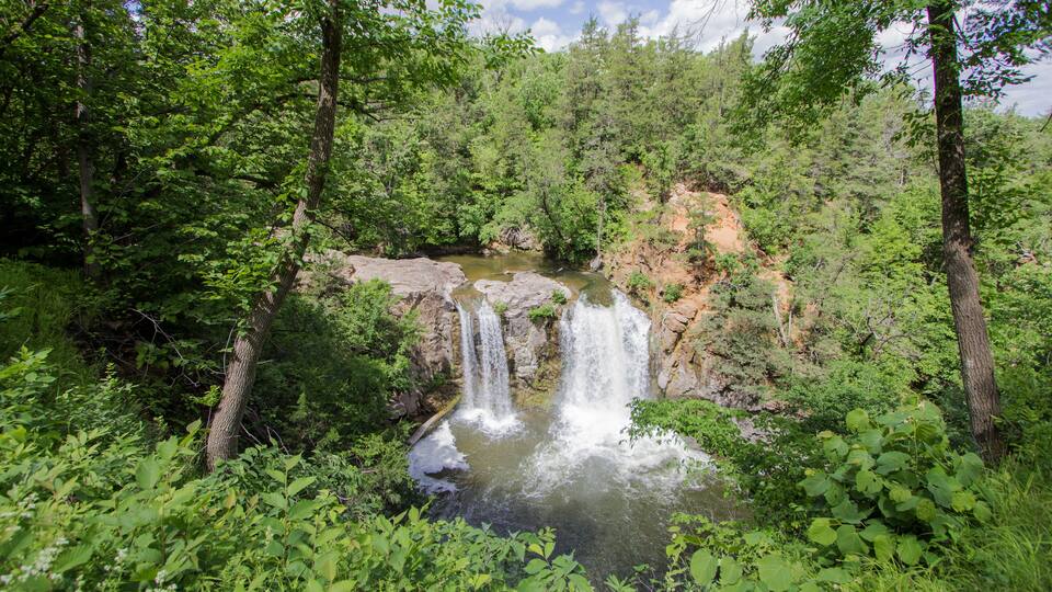 A waterfall surrounded by dense forest.