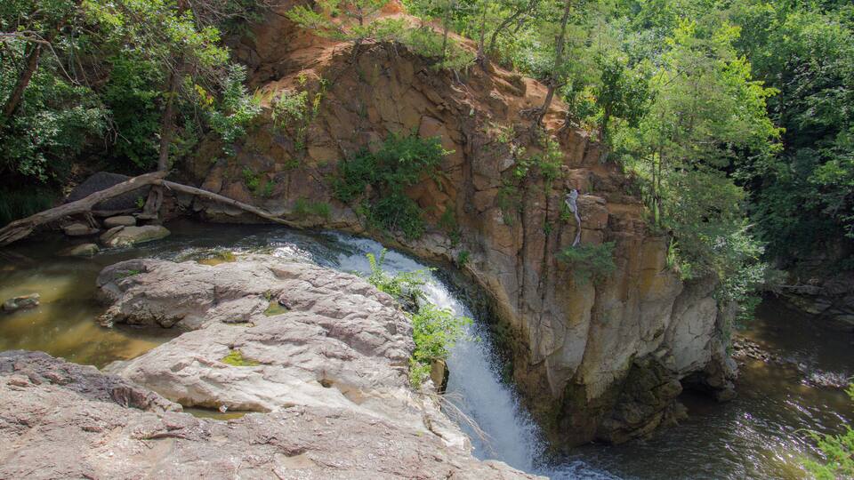 A waterfall cascading over rocks in a forested area.
