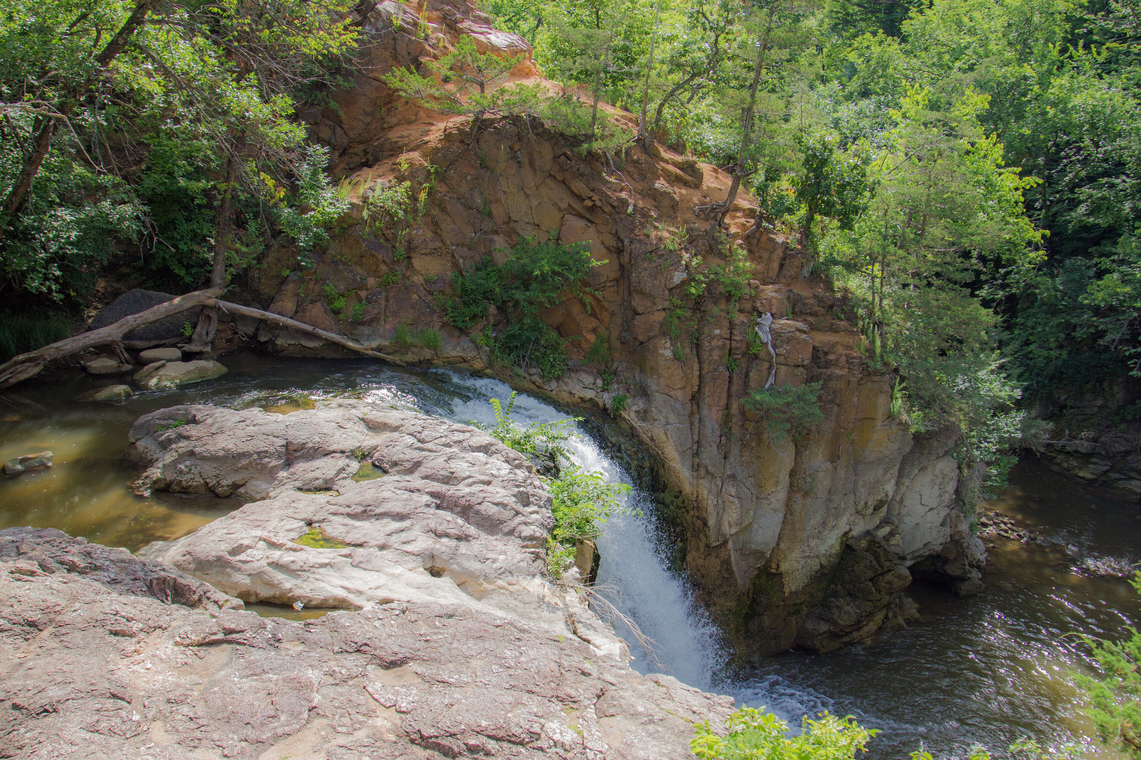 A waterfall cascading over rocks in a forested area.