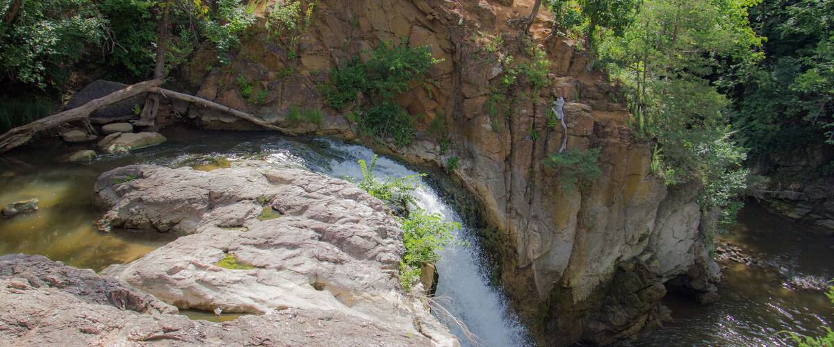 A waterfall cascading over rocks in a forested area.