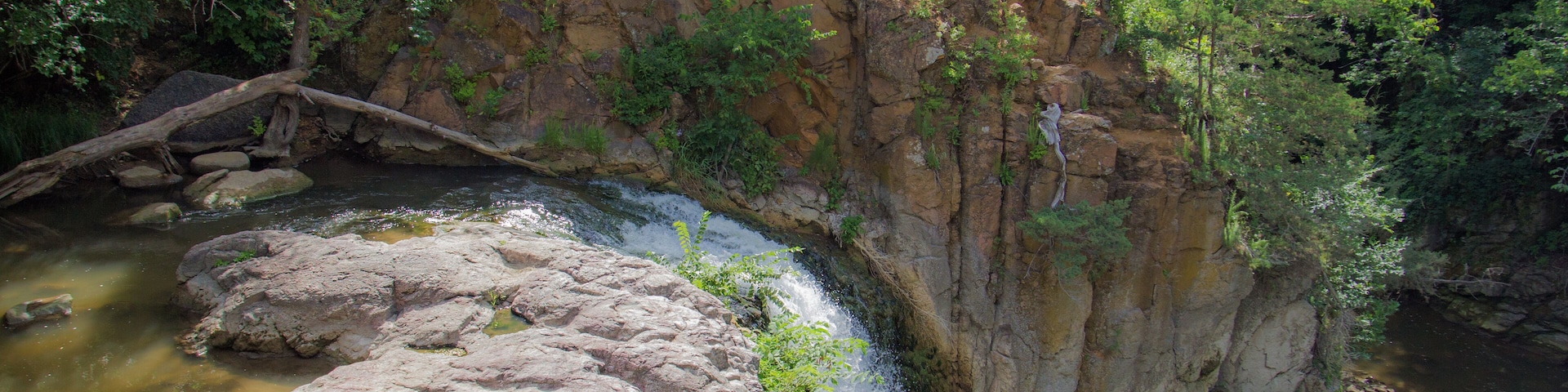 A waterfall cascading over rocks in a forested area.