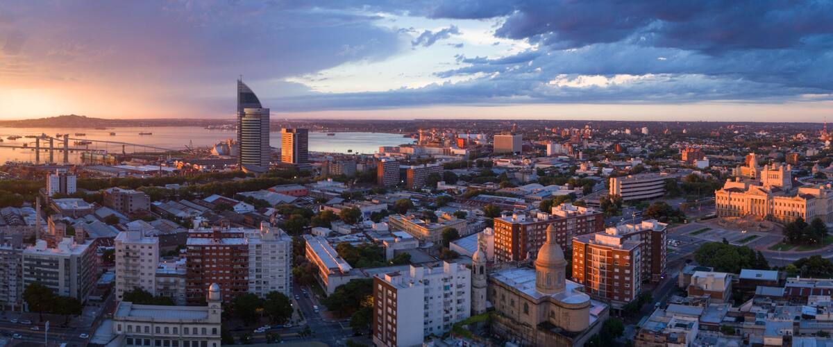 A cityscape with a prominent modern skyscraper, historic buildings, and a river.