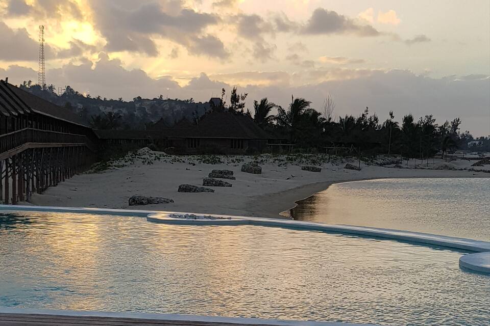 A beach with a wooden deck and a calm sea.