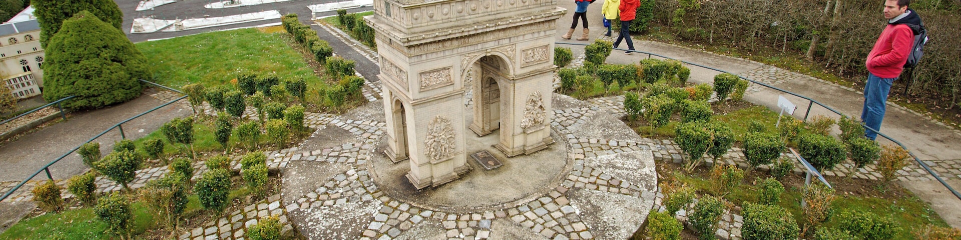 Una maqueta de la Torre Eiffel rodeada por un jardín con un monumento central.
