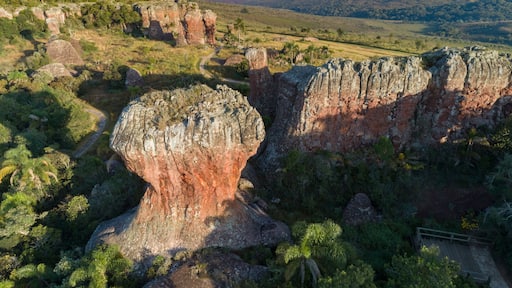 Un paesaggio caratterizzato da formazioni rocciose, un sentiero sinuoso e una vista lontana delle colline.