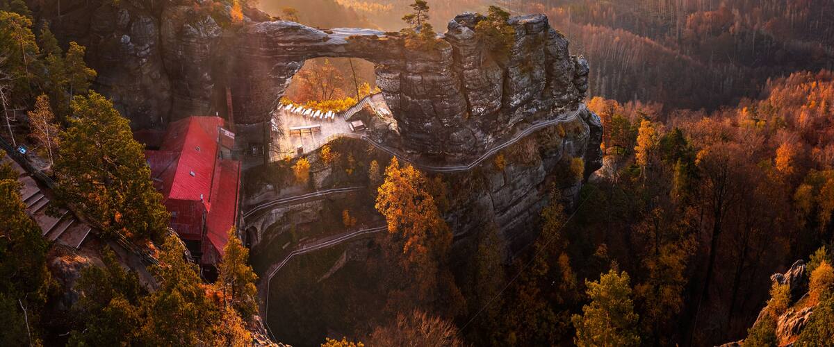 Hrensko, Czech Republic - Aerial panoramic view of the beautiful Pravcicka Brana (Pravcicka Gate) in Bohemian Switzerland National Park, the biggest natural arch in Europe with a warm autumn sunrise