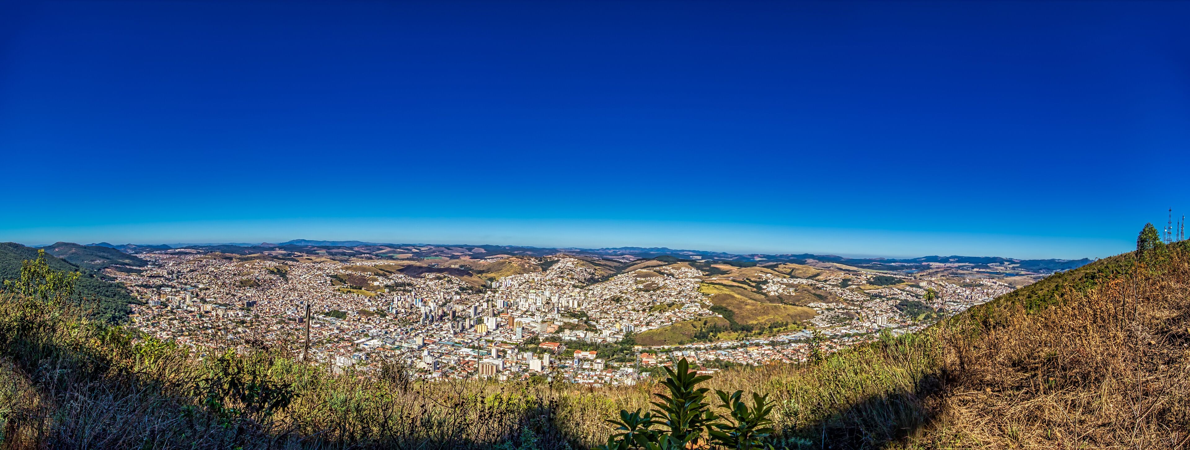 A panoramic view of a city with rolling hills in the background.