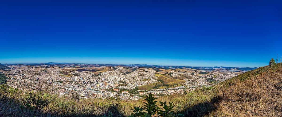 A panoramic view of a city with rolling hills in the background.