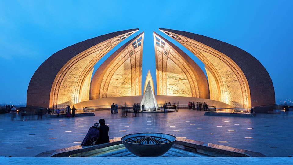 A large, illuminated dome-shaped building with a central fountain and a bowl in the foreground.