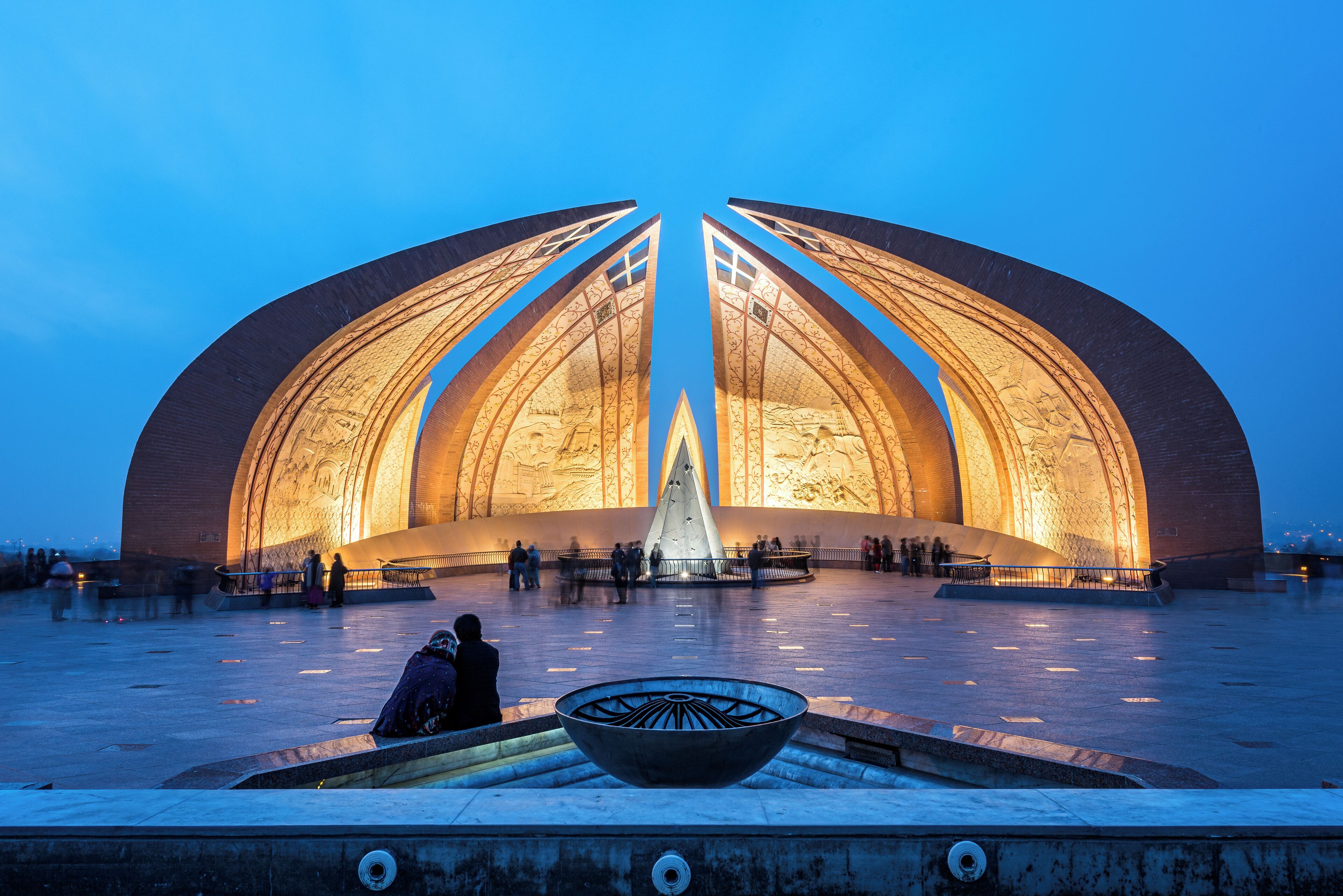 A large, illuminated dome-shaped building with a central fountain and a bowl in the foreground.
