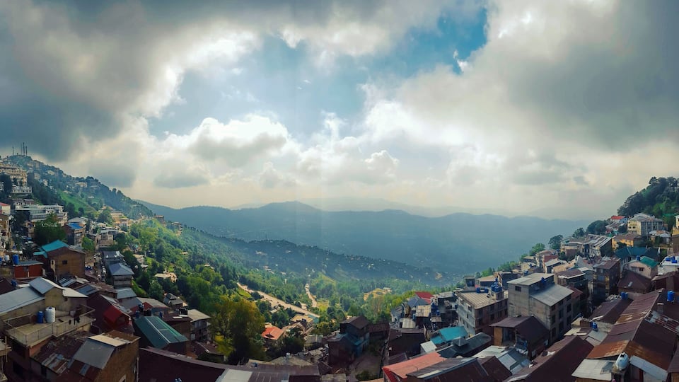 A mountainous town with dense housing and a valley below.