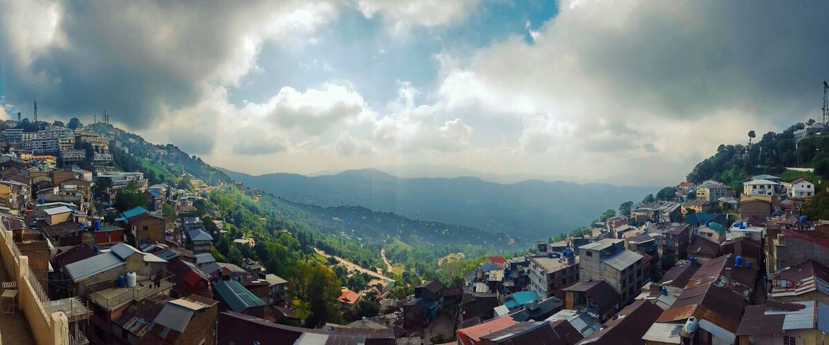 A mountainous town with dense housing and a valley below.