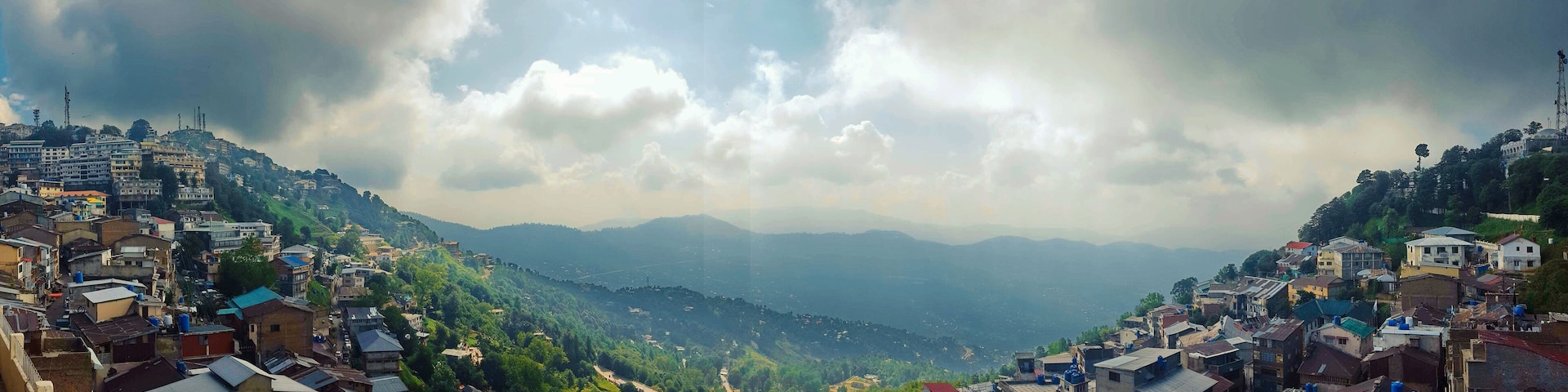 A mountainous town with dense housing and a valley below.