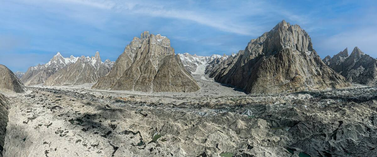 Rugged mountain peaks with snow-capped summits and a rocky foreground.