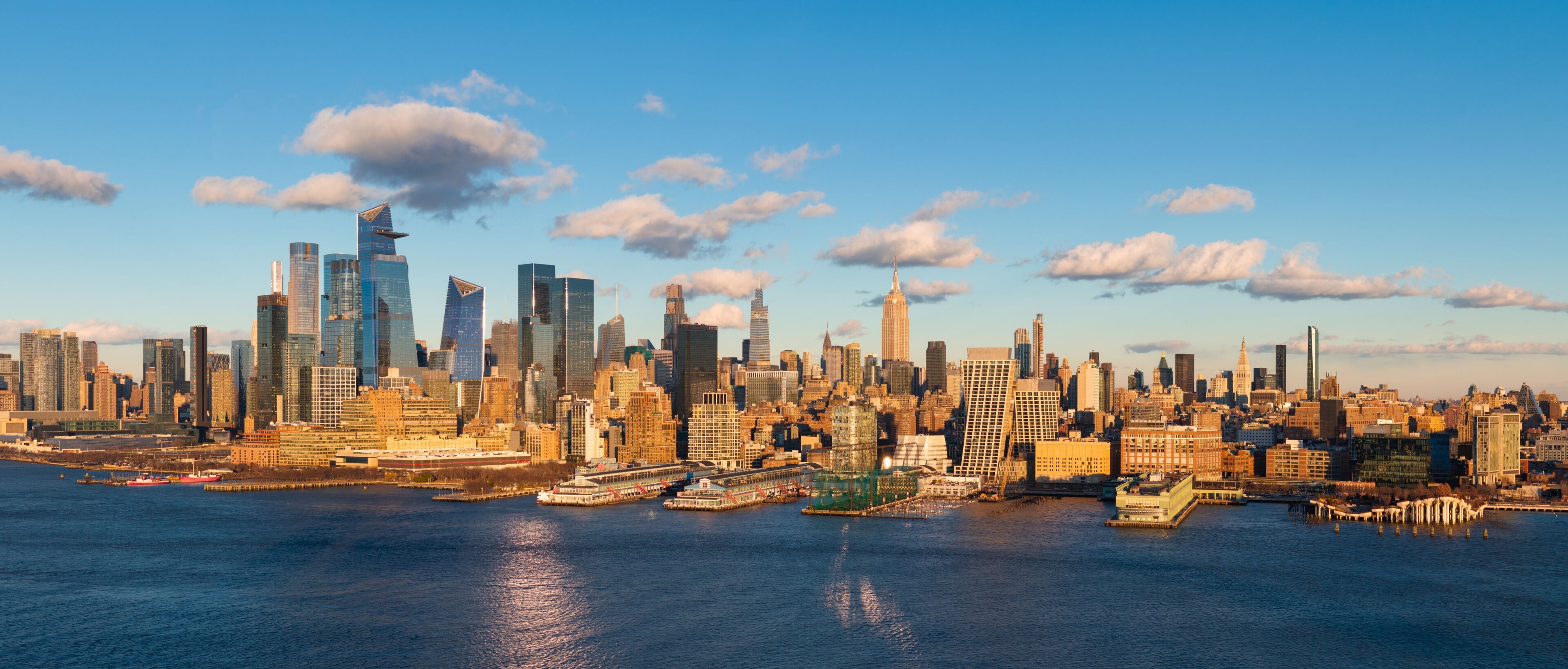 Aerial view of New York City skyline with Hudson River Park, Manhattan skyscrapers and Hudson Yards. The urban landscape includes Midtown high-rise buildings, West Village and Chelsea piers