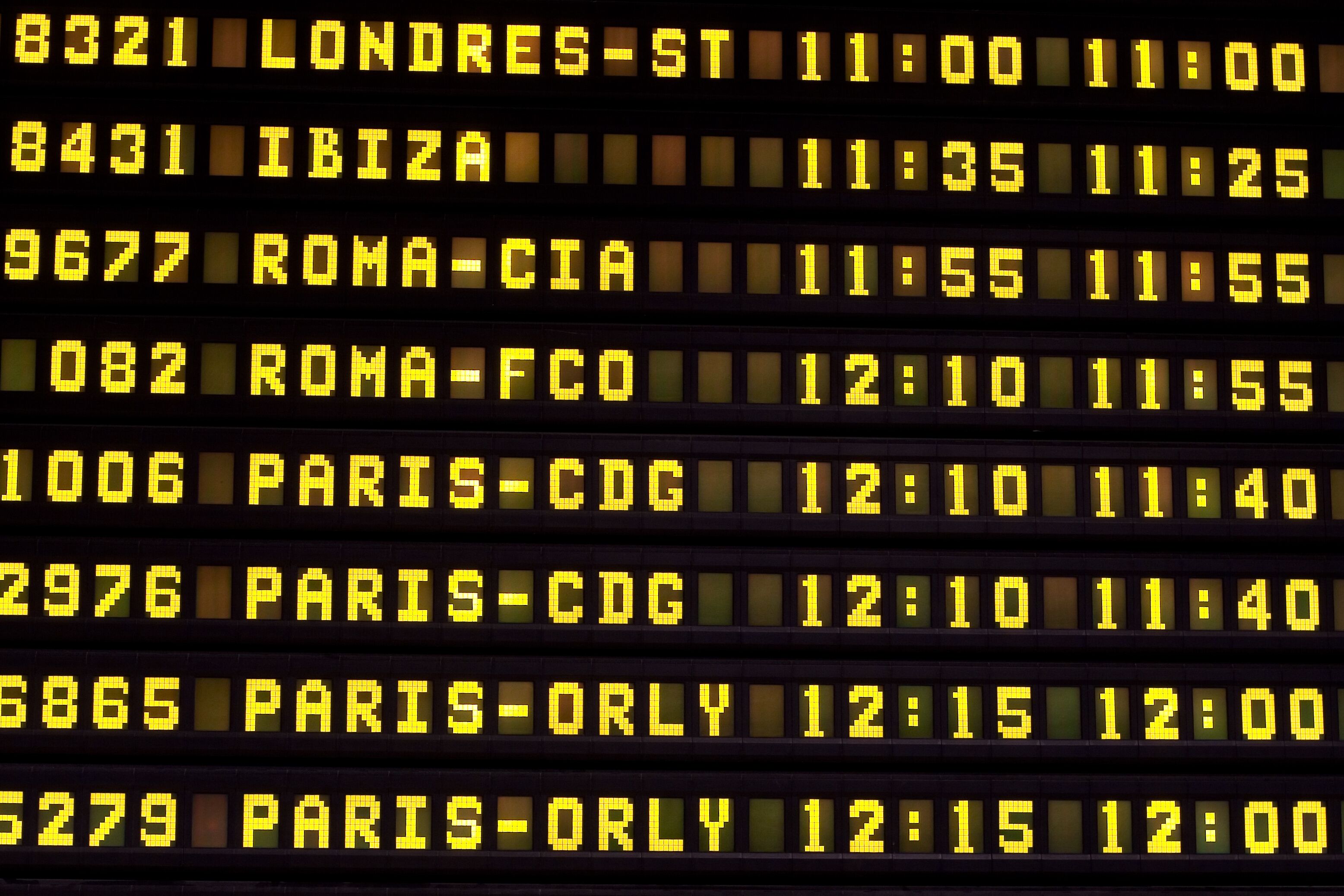 A digital flight information board with flight numbers, destinations, and times.