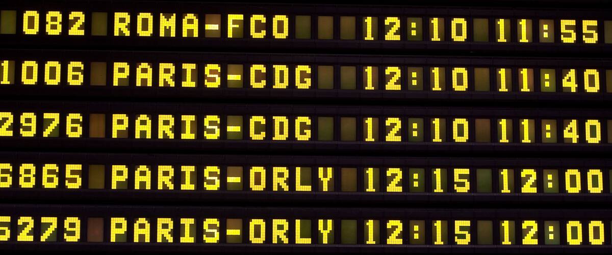 A digital flight information board with flight numbers, destinations, and times.
