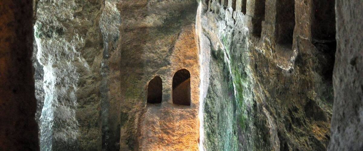 An ancient cave with arched passageways and rock formations.