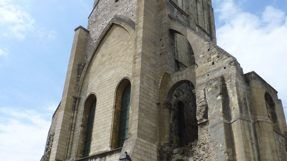 An old stone church with a tall bell tower and arched windows.
