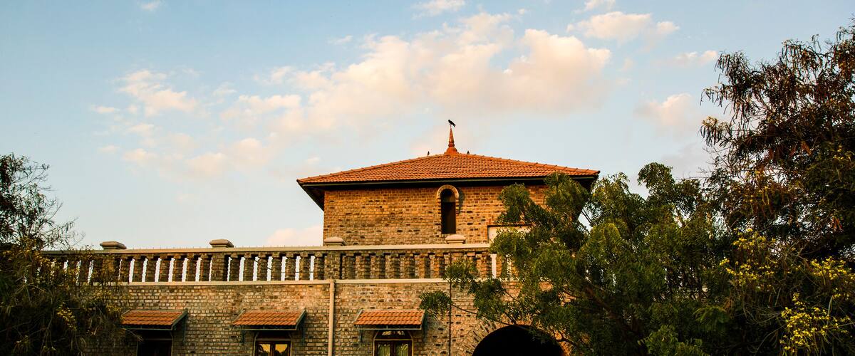 A historic building with a tiled roof, arched windows, and a stone facade.