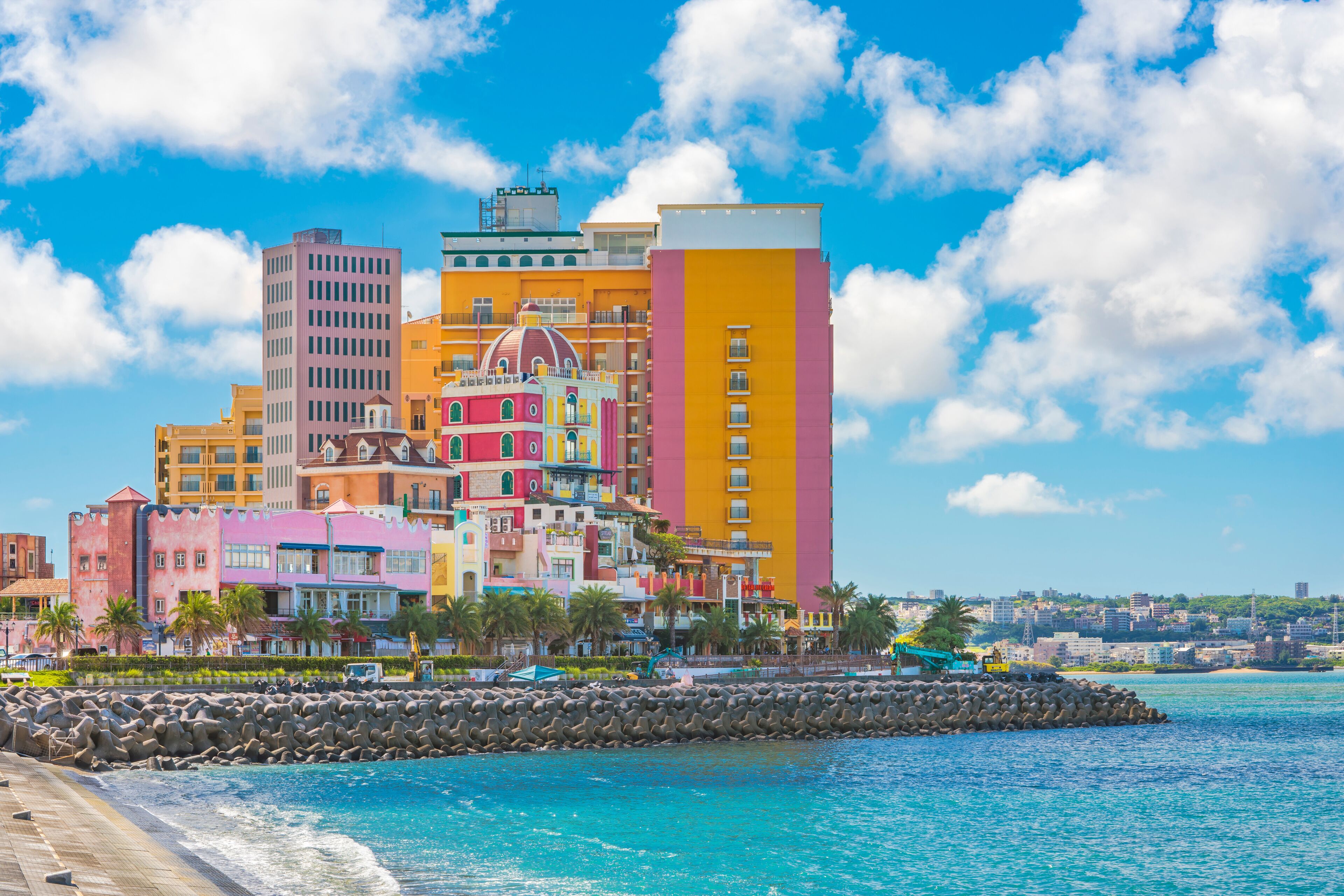 Beach coast lined with palm trees of Distortion Seaside, Oak fashion, Depot Island Seaside buildings and Vessel Hotel Campana in the vicinity of the American Village in Chatan City of Okinawa.