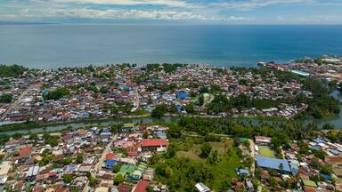Iligan City: Busy city in daytime, residential area and commercial buildings. Northern Mindanao, Philippines. Cityscape.