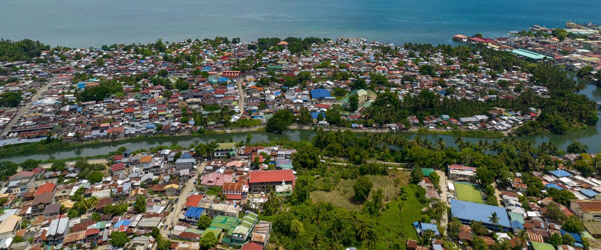 A coastal town with dense housing, a river, and a large body of water.