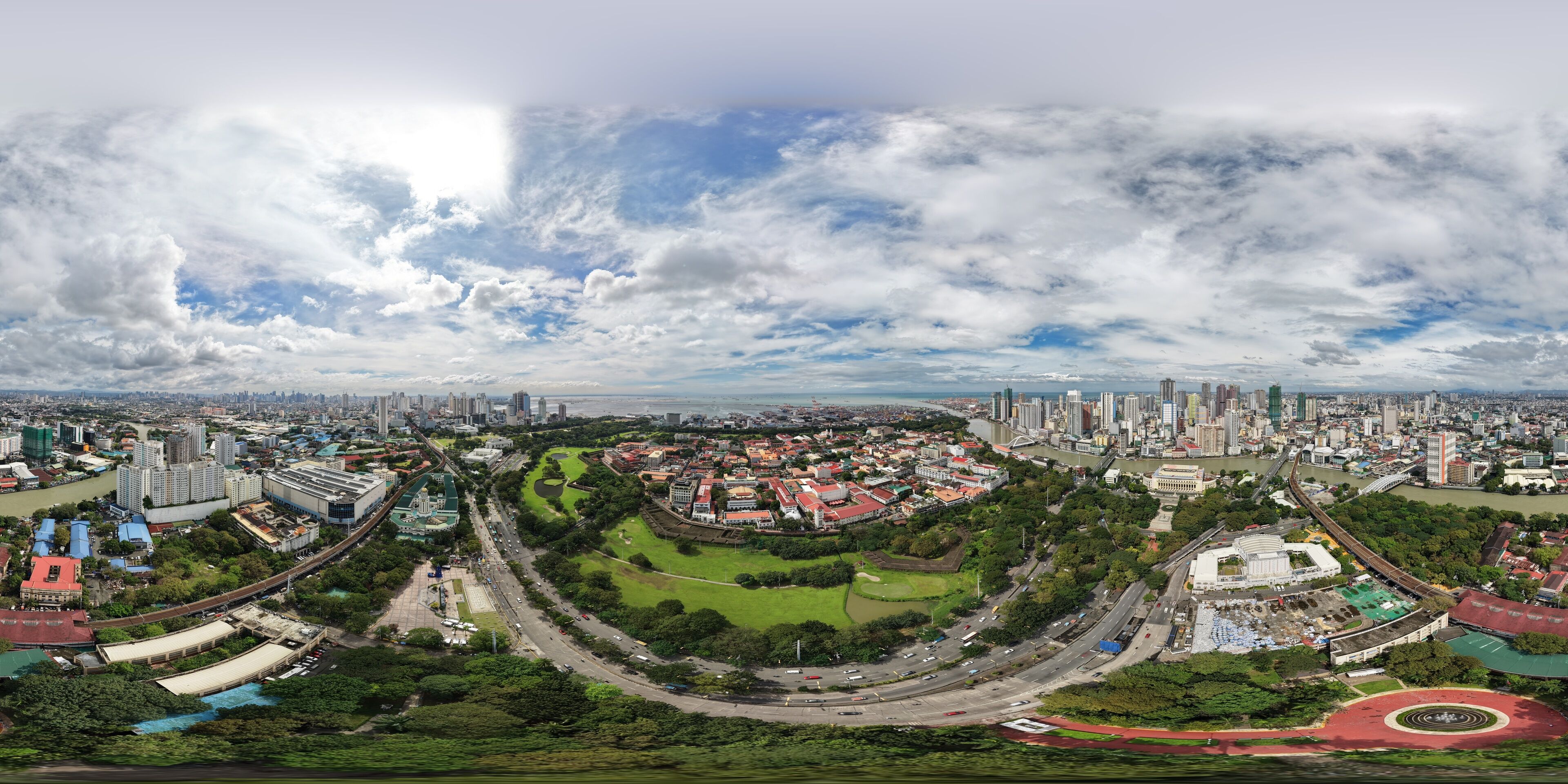 A panoramic view of a city with a river, green spaces, and a mix of modern and traditional architecture.
