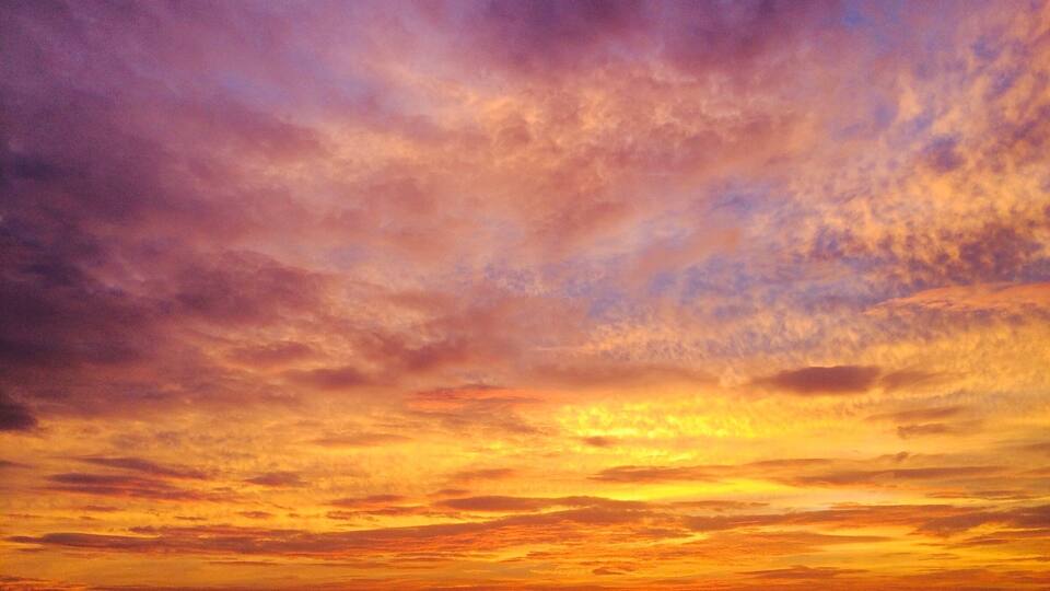 A sunset with a vibrant sky filled with orange and purple hues.