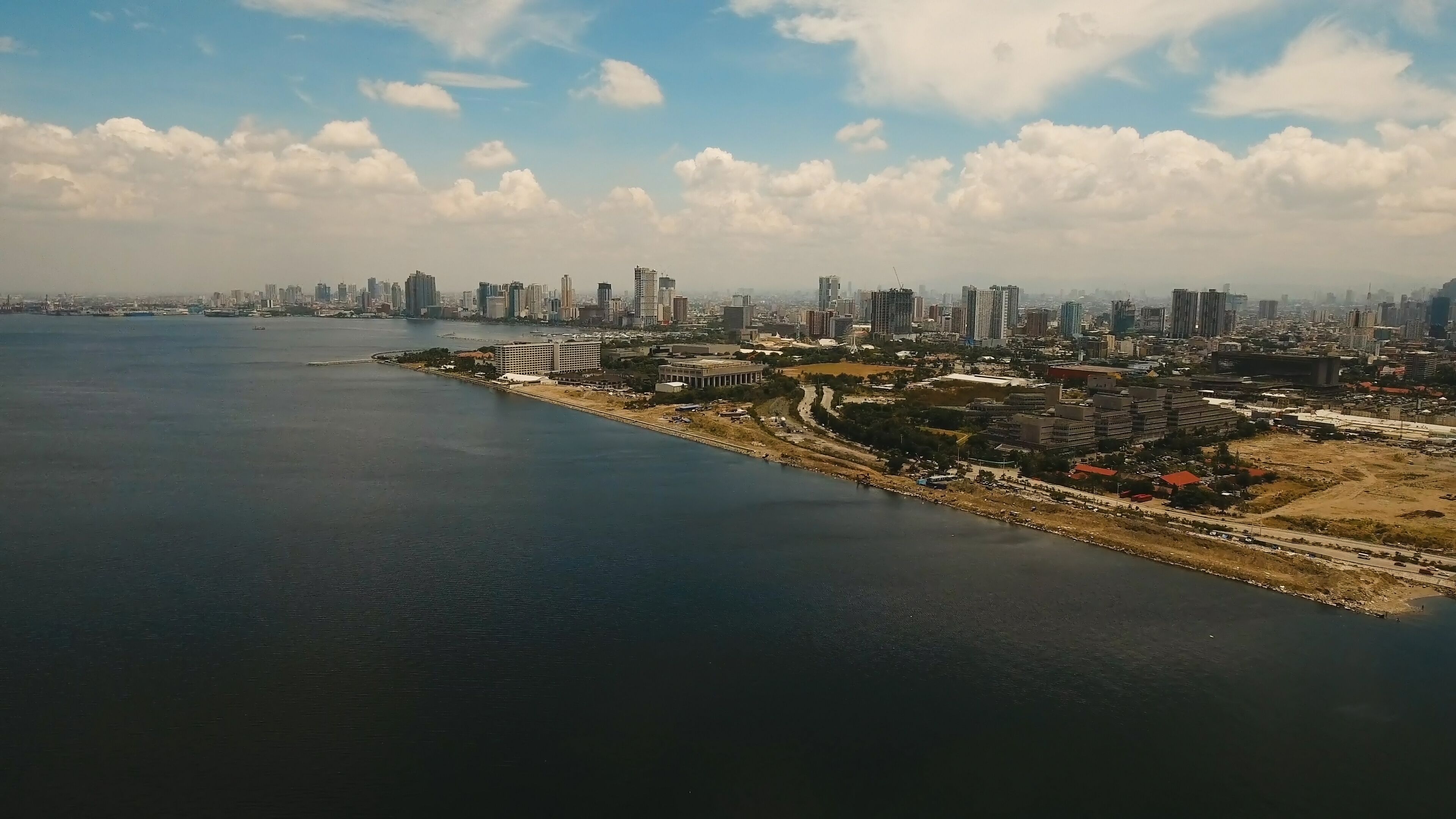 Aerial view of Manila city. Fly over city with skyscrapers and buildings. Aerial skyline of Manila . Modern city by sea, highway, cars, skyscrapers, shopping malls. Makati district. Travel concept.