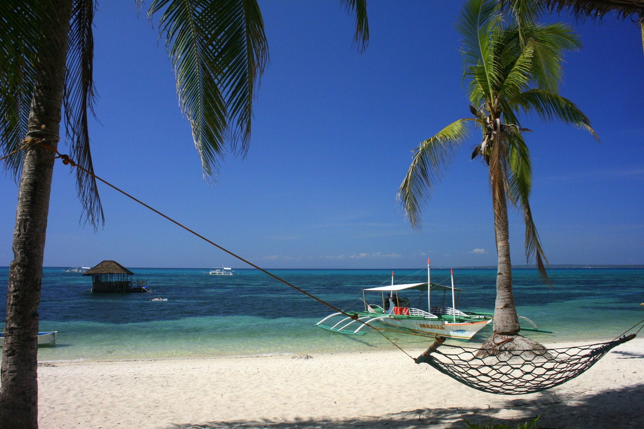 White sandy beach and crystal clear, turquoise water in Malapascua, Cebu, Philippines.