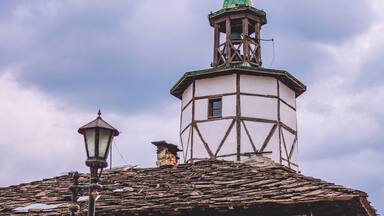 A traditional building with a green spire and a stone lantern.