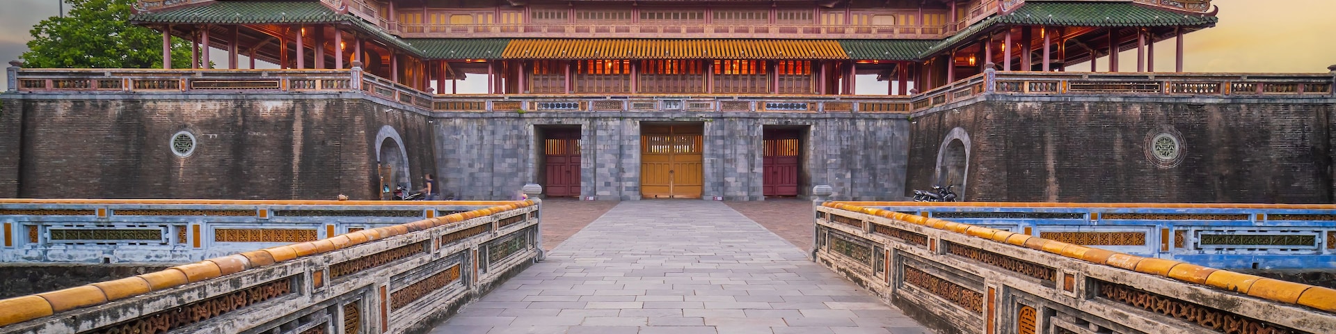 A traditional Chinese building with ornate architecture, a large central gate, and a tiled walkway.
