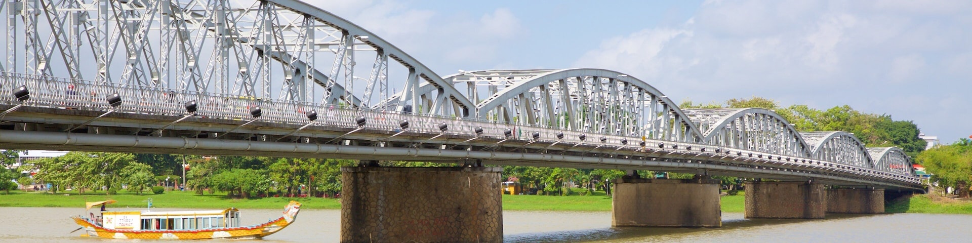 Puente Thanh Toan ofreciendo un río o arroyo, botes y un puente