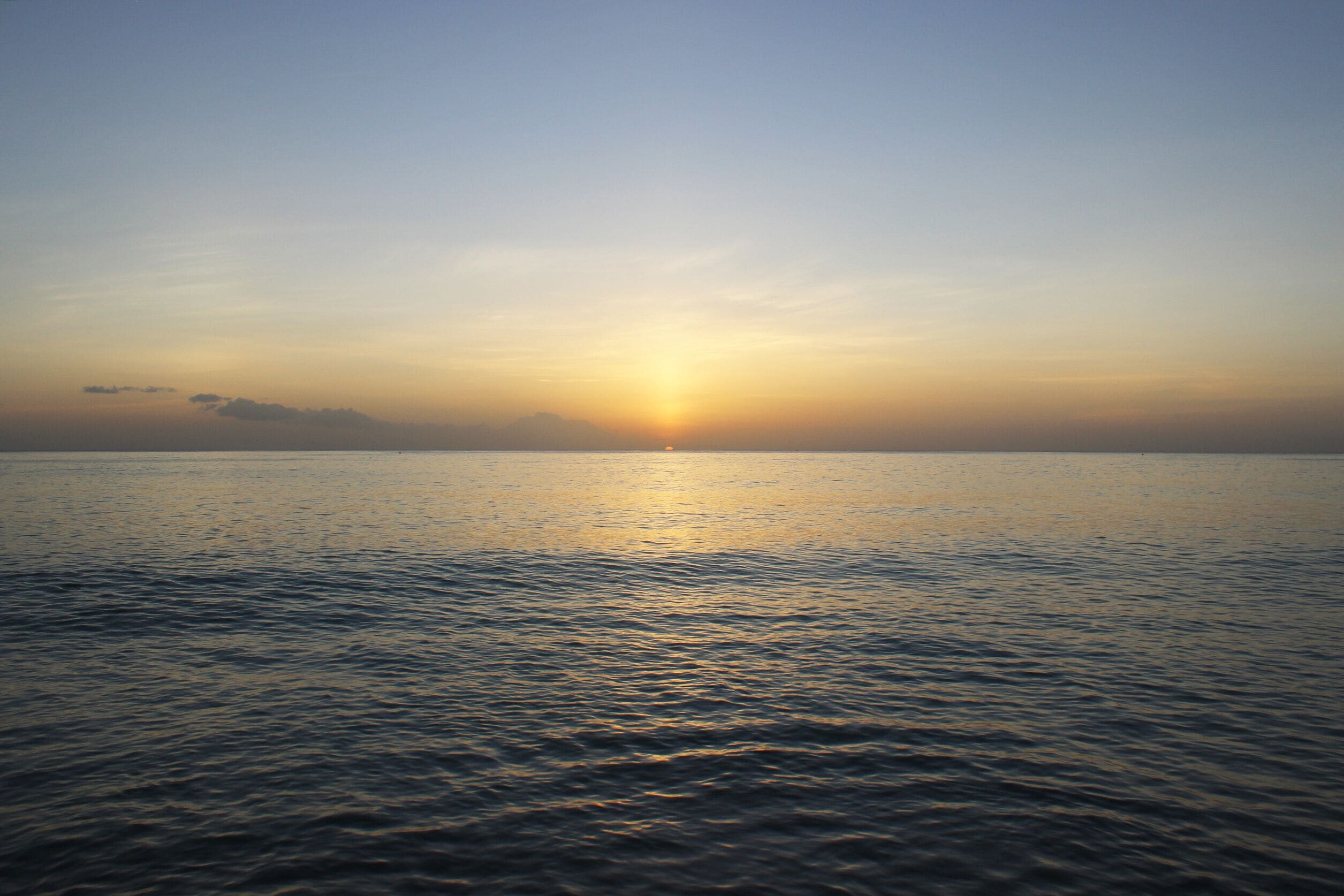Calming and beautiful orange sunset against blue seashore