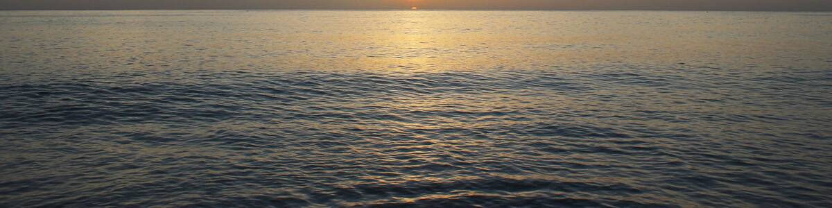 Calming and beautiful orange sunset against blue seashore