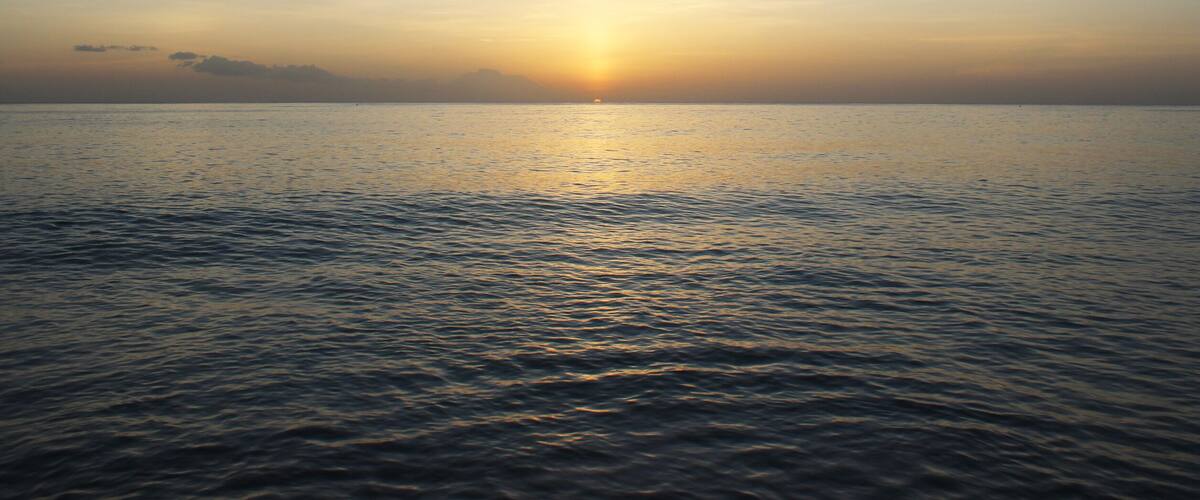 Calming and beautiful orange sunset against blue seashore