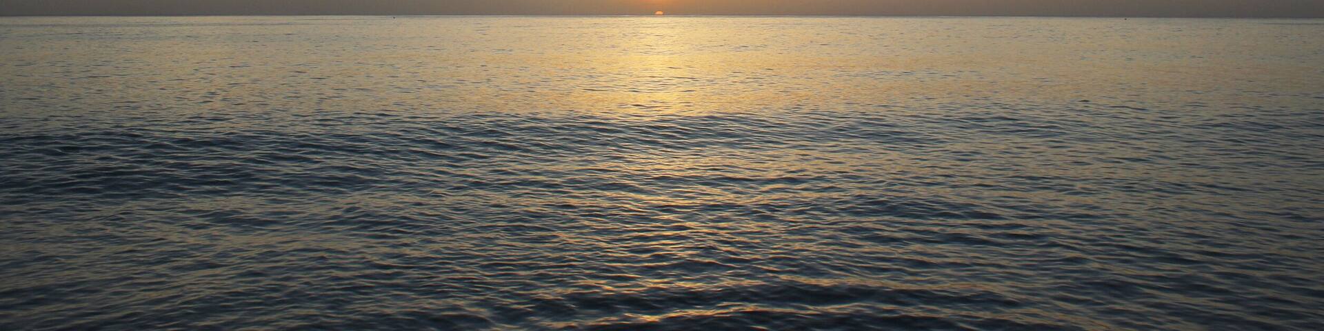 Calming and beautiful orange sunset against blue seashore